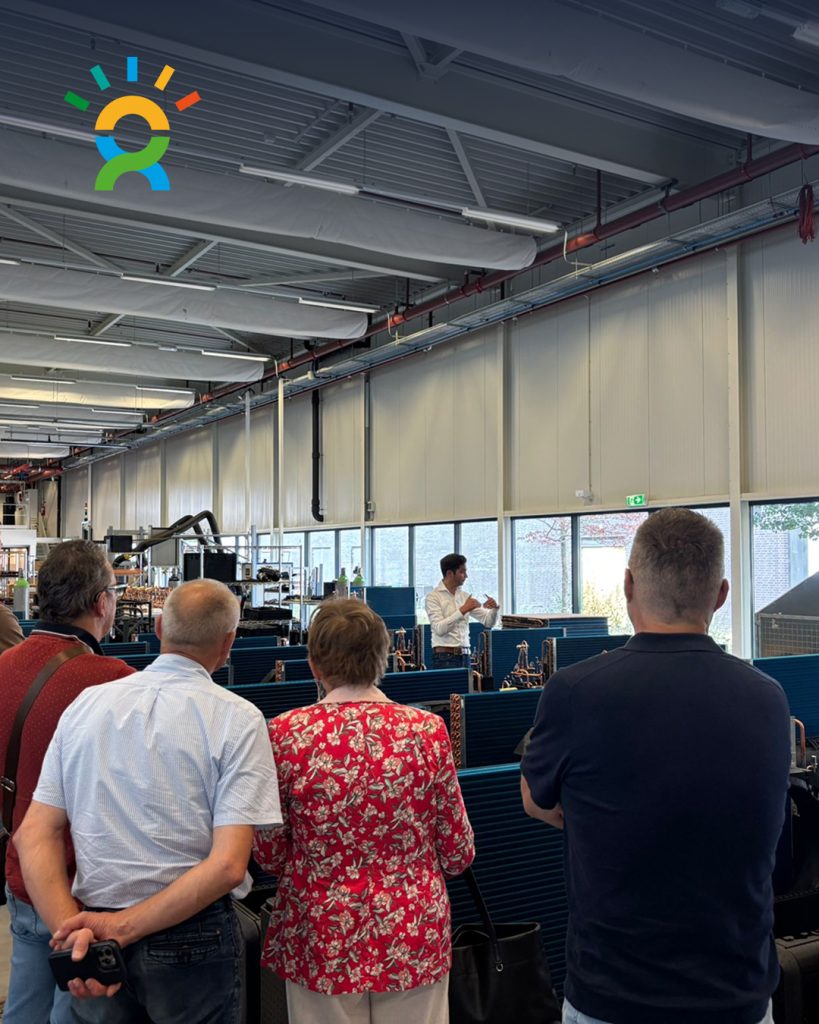 Bezoekers tijdens een rondleiding door de WeHeat fabriek, georganiseerd door De Groene Generatie, waar ze uitleg krijgen over warmtepompen en productie.