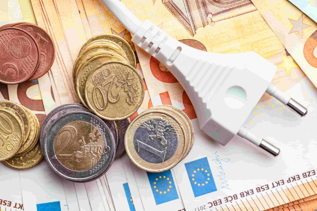 Eurobiljetten, munten en een stekker als symbool voor stijgende energiekosten en dalende subsidie het ISDE-budget.